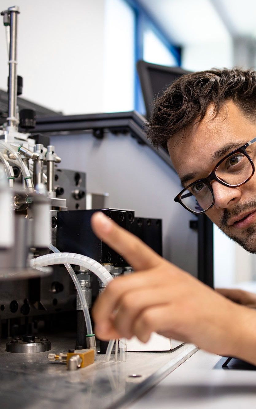 experienced-engineer-working-new-automated-robotic-machine Młody człowiek pracuje przy nowoczesnym urządzeniu
