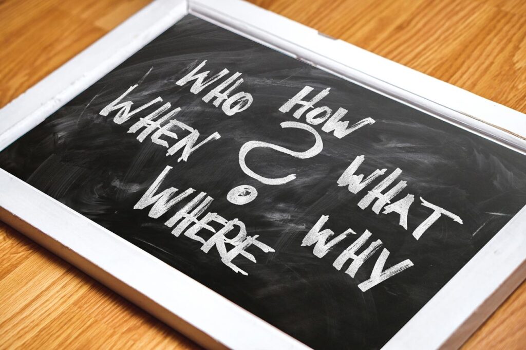 Tablica z pytaniami: WHO HOW WHEN WHAT? pisanymi kredą